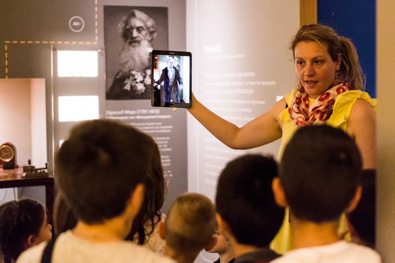 Διεθνής Ημέρα Μουσείων: το τιμώμενο Μουσείο Τηλεπικοινωνιών γιορτάζει - Εκπαδεύτρια δείχνει εφευρέτη στο tablet