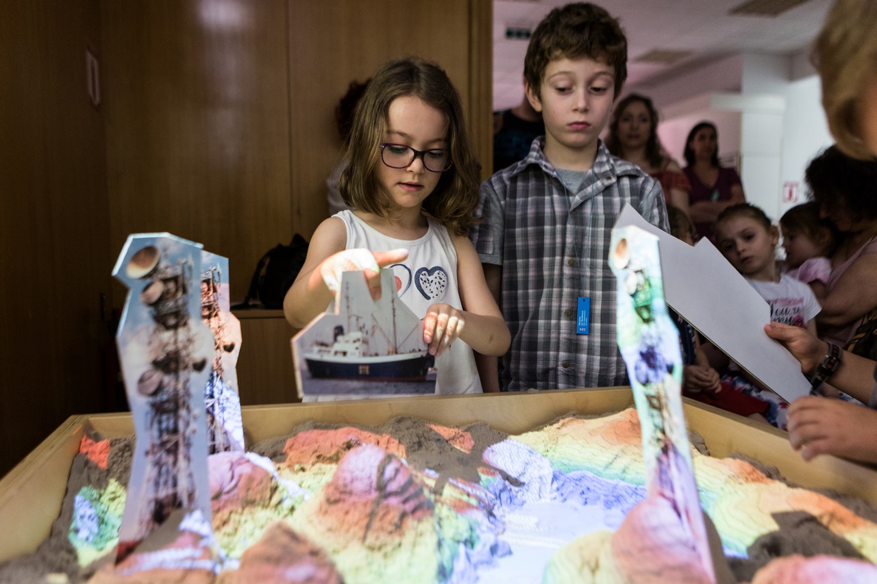 Διεθνής Ημέρα Μουσείων: το τιμώμενο Μουσείο Τηλεπικοινωνιών γιορτάζει - Κορίτσι κρατά ένα χάρτινο πλοίο μπροστά σε έκθεμα